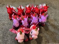 Front view of all 11 unicorn stuffed toys arranged on carpet, showing colors and features clearly