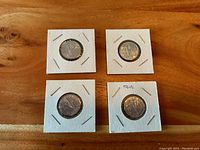 Front sides of four 1945 Victory Nickels in cardboard holders showing the Victory design with 'V' and maple leaves.