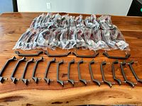 Full lot of 62 cabinet handles arranged on wooden surface, many still in original plastic packaging with Richelieu branding visible.