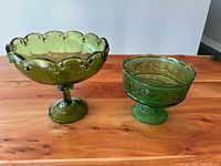 Both green Depression glass dishes on wood surface showing size difference and color
