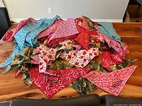 Pile of assorted triangular dog bandanas in various colors and patterns