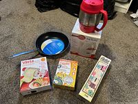 Overview of all kitchen items including Bubba Keg, frying pan, and boxed kitchen gadgets on carpeted floor.