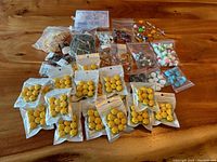 Overview of all resin charms laid on wooden table in separate bags.
