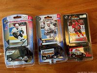 Front view of the three Zamboni toy vehicles in blister packaging with corresponding player cards visible.