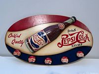 Full front view of the oval wooden Pepsi-Cola wall art sign showing the 3D bottle and bottle caps, colorful painted background, and text.