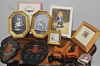 Full lot display of art prints, decorative plaques, and picture holders on a wooden surface.