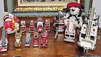 Overview photo showing all fire trucks and plush bear arranged on a wooden surface