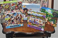 View of five assorted puzzles on table showing artwork and puzzle types