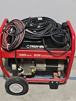 Side-front view of generator showing red frame, wheels, 6000/8250W ratings