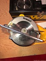 Top-down photo of DeWalt cordless trim saw with circular blade mounted, showing blade guard and front metal guide.