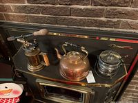 Full lot showing left to right: CPR blowtorch with wooden handle, copper kettle with wooden handle, and perforated metal pot with lid on black surface.