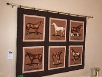 Front view of quilted wall hanging showing six horse breed illustration panels mounted on metal rod with hardware.