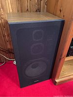 Front view of one Technics SB-2634 speaker with wool grain sides, black front grill showing speaker drivers.