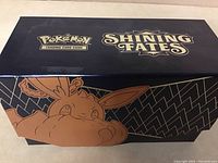 Closed rectangular box with Pokémon Shining Fates branding and Eevee illustration.