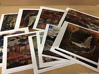 Ten cardstock art prints arranged overlapping, showcasing various nature landscapes in painterly art style.