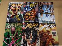 Six Flash comic books arranged in two rows on a beige surface, each with distinct cover art.