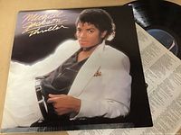 Photo of the Michael Jackson Thriller vinyl album cover and record, showing clean condition of the vinyl and the cover art with Michael Jackson in a white jacket.