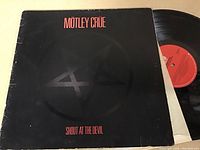 Front cover of Motley Crue Shout at the Devil LP showing black background, red text, and pentagram symbol.