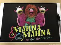 Photo of the Muppets Mahna Mahna art print showing the characters and colorful text on black background.