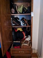 Wardrobe with shelves holding multiple handbags, evening bags, purses, and various hats including woven, felt, baseball cap, and fur hats