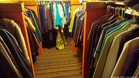 Two densely packed clothing racks filled with assorted vintage women's clothing in varied colors and styles