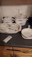 Full set of 13 CorningWare pieces including casserole dishes with lids, baking tray, and two skillets, all with classic blue floral pattern.