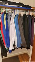 Photo of assorted women's jackets and coats hanging in closet, showing various colors, styles, and brands.