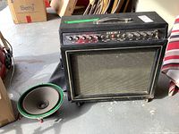 Full view of Gemini I amplifier cabinet on concrete floor with 12-inch speaker driver beside it