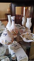 Group photo showing all Aynsley Cottage Garden china pieces and ceramic owls together on glass shelf.