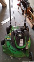 Front view of the green Lawn Boy gas powered lawn mower labeled Easy Mulch, showing the black engine cover, pull start, and part of the handlebar.