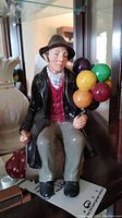 Front view of Royal Doulton The Balloon Man figurine showing detailed facial features, clothing, and balloons.
