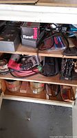 Shelf with pink and black electric drill and various metal containers below
