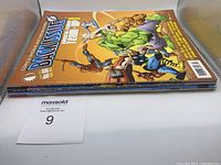 Photo showing stack of three Back Issue comic magazines with visible colorful cover featuring Marvel superheroes and others.