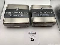 Front view of two sealed metal tins labeled Tellstones King's Gambit.