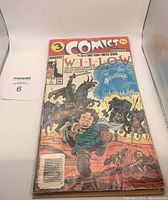 Photo showing Willow Issue 1 comic book cover featuring a man running holding a baby fleeing from black-armored horse riders with a large ominous face behind them.
