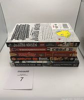 Stacked view of 5 manga books showing titles and spines in a pile