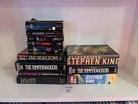 Books stacked in two piles, showing book titles and signs of wear on covers and spines.