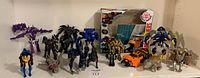 Group of Transformers figures in robot and vehicle form with box back panel in background