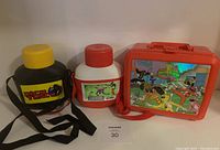 Front view of three items: Dick Tracy canteen, Beetlejuice canteen, Power Rangers lunchbox