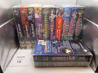 Photo of 12 vintage anime VHS tapes showing their spines in a row. Titles include Bubblegum Crisis (4 volumes), Sakura Wars (2 volumes), Raideen Battles (3 volumes), and Goku Midnight Eye (2 volumes).