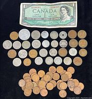 Top view of the coin and currency collection showing Canadian one dollar bill and various coins including Canadian pennies, Japanese yen, Hong Kong and European coins.