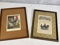 Two framed prints side by side on white surface. Left print has brown matting with image of white and black rooster and hens. Right print has colorful hex pattern matting with vintage newspaper-style Poultry Keeper page with black and white bird images.