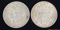 Obverse of two Morgan dollar coins dated 1878 (left) and 1900 (right) on black background