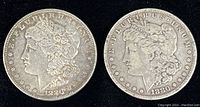 Obverse of two 1880 Morgan silver dollar coins showing Liberty head design, one with no mint mark and the other with O mint mark.