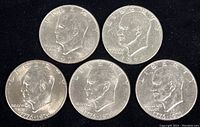 Obverse side of five Eisenhower dollar coins including 1972, 1978, and three 1776-1976 Bicentennial coins showing profiles of President Eisenhower.