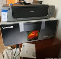 Canon Pixma Pro 9000 printer on box with visible quick start guide in front