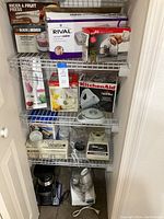 Overview of small appliances on shelving including boxed and unboxed items