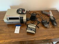 NES console with controller, power adapter, and cables on wood table