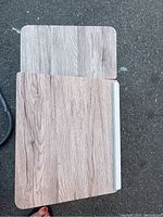 Close-up of desk's wood grain laminated two-section top surface, one part flat, one part adjustable with wear marks