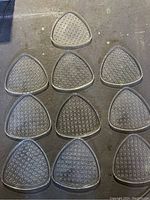 Overview of all 10 glass buffet plates laid out on the ground showing triangular shape and patterned design.